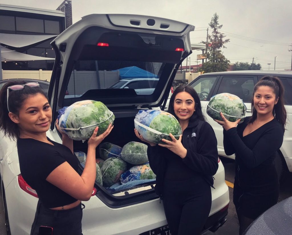 Prime Social employees show off frozen turkey donations for Full House Feast